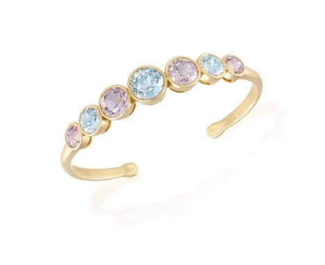 A KUNZITE AND BLUE TOPAZ BANGLE, BY MICHELE DELLA VALLEComposed of graduated circular-cut kunzites interspersed with similarl