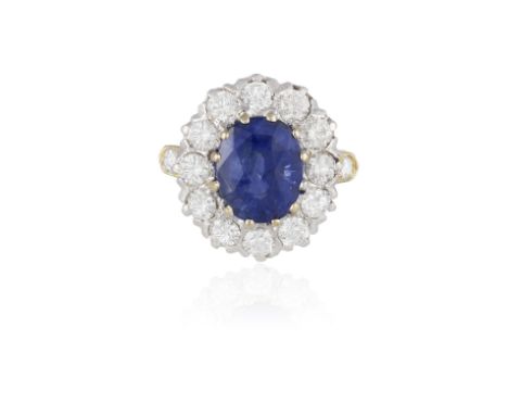 A SAPPHIRE AND DIAMOND CLUSTER RINGThe oval-shaped sapphire weighing approximately 5.15cts within a twelve-claw setting and a