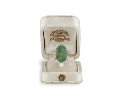 A BELLE EPOQUE JADE AND DIAMOND DRESS RING, CIRCA 1910Composed of an oval-shaped carved jade plaque accented with an old Euro