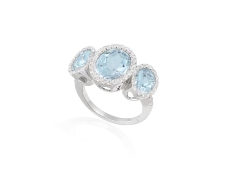 AN AQUAMARINE AND DIAMOND THREE-STONE RINGComposed of an oval mixed-cut aquamarine at the centre within a surround of brillia