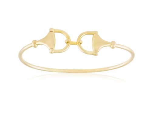 A GOLD BANGLE, BY GUCCIThe frontispiece designed as a stirrup, to a plain 18K gold bangle, signed Gucci, maker's mark, Italia