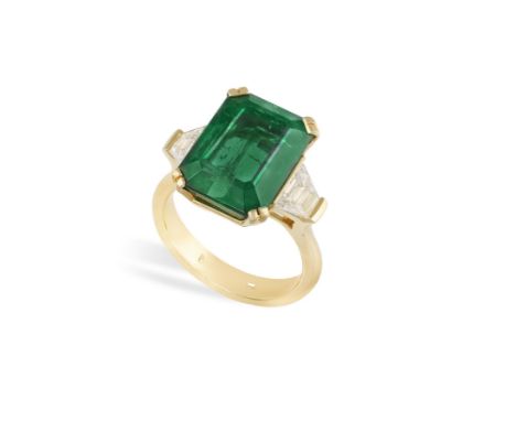 AN IMPRESSIVE EMERALD AND DIAMOND RINGThe cut-cornered rectangular emerald weighing 11.77cts within a double four-claw settin