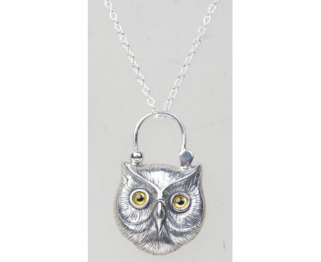 A silver pendant necklace having a shield shaped lock pendant in the form of an owl with glass eyes with a malachite panel to