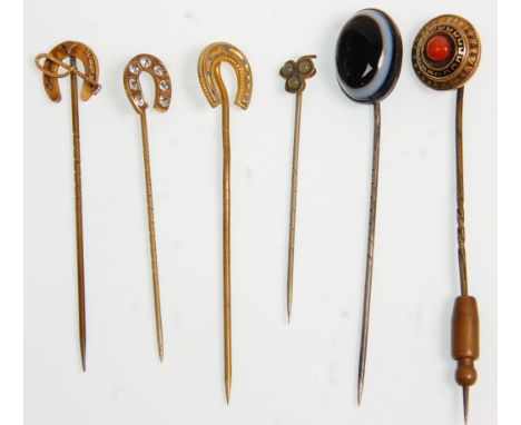 A group of six vintage ladies stick pins to include a 9ct gold horseshoe and crop example and two other gold tone horseshoe p