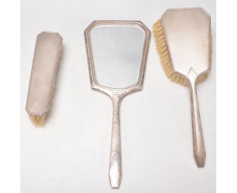 A silver hallmarked 1940's silver dressing table set to include a mirror, hair brush and clothes brush all with engine turned