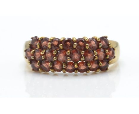 A 9ct gold garnet cluster ring. The ring inset with 22 round cut&nbsp; orange / red garnet stones on tapering shoulders with 