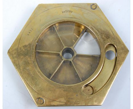 An early 20th Century patent brass countertop till of hexagonal form having a round glass panel with round mechanism below.
