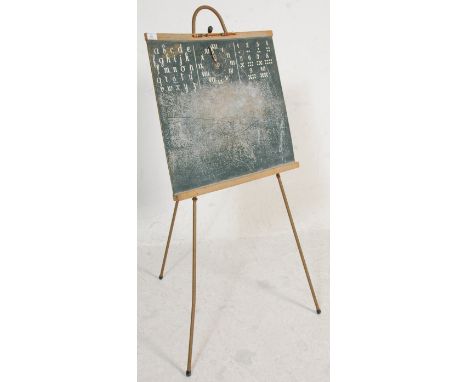 A vintage retro 1950's school black board having alphabet letters, a clock with moveable hand and numbers to the top of the b