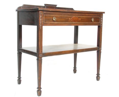 An early 20th Century Edwardian mahogany serving table having a gallery back, with a single drawer adorned with carved border