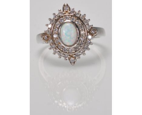 A stamped 925 silver panel ring having a central oval opal with concentric halo's of CZ's. Weight 4.3g. Size P.5.