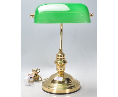 A vintage 20th Century bankers desk lamp having a round stepped base with a green glass rotating shade.&nbsp;