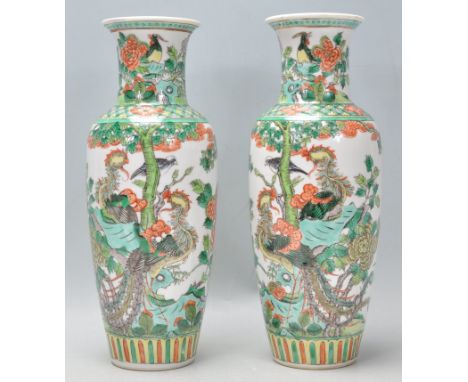 A pair of 19th Century Chinese famille verte porcelain baluster vases being hand enamelled over a transparent glaze decorated