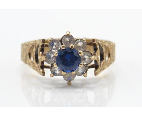 A 9ct gold sapphire and diamond cluster ring. The central sapphire within a halo of diamonds. Prong setting with pierced shou