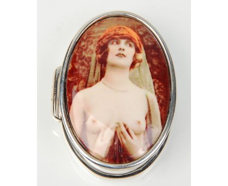 A stamped 925 silver pill box of oval form having an enamelled panel depicting a semi nude woman. Weight 19.5g. Measures 3.6c