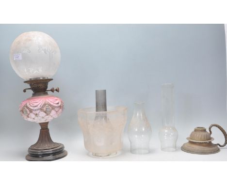 A 19th Century Victorian oil lamp having a pink curtain and tassel design reservoir with a bulbous shade to the top etched wi