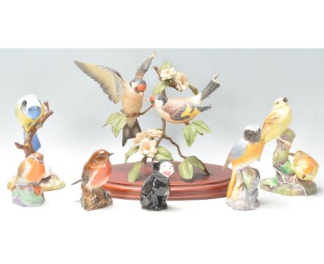 A collection of ceramic bird figurines to include a Royal Worcester Redstart, a Beswick Robin, a Royal Crown Derby Blue Tit, 