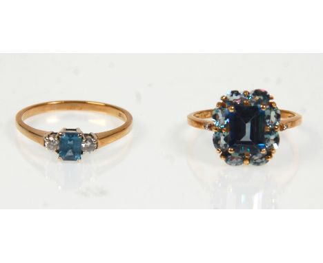 Two 9ct yellow ladies dress rings. One set with a large square faceted cut blue stone surround by oval blue cut stones with f