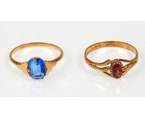 Two 9ct yellow gold ladies rings. One set with an oval faceted cut red stone to decorative pierced split shoulders. Hallmarke