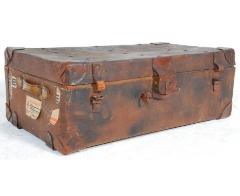 A vintage 20th Century brown leather travel trunk case / coffee table having brass studded with leather handles and straps. T