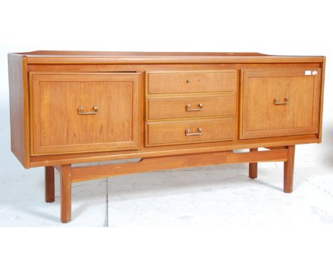 A vintage 20th century teak wood sideboard having a central bank of three drawers flanked by cupboard to either sides with br