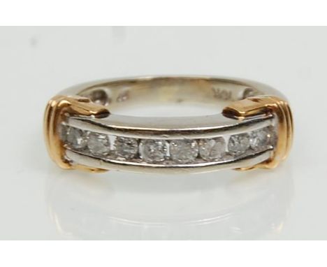 A stamped 9ct two tone gold half eternity ring channel set with eight round cut diamonds. Weight 3.8g. Size L.