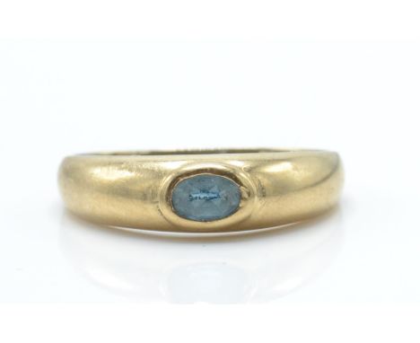 A 9ct gold and sapphire dome ring. The ring set with oval facet cut sapphire in domed ring with tapering shoulders to plain s