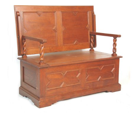 A 20th Century jacobean revival oak monks bench settle table having geometric mouldings and carved&nbsp;details, having a rec