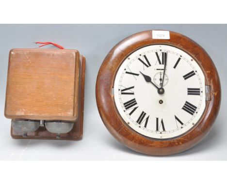 An early 20th Century station wall clock having a round white enamelled face with roman numeral to the chapter ring with subs