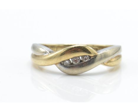 A 9ct gold and diamond bi-colour crossover ring.&nbsp; The ring with white and yellow cross over design having inset 3 diamon