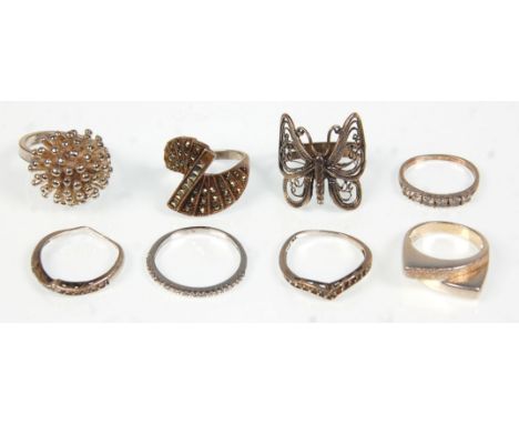 A collection of eight ladies silver rings to include two wishbone rings set with marcasites, a filigree butterfly ring, a gra