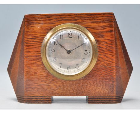 An early 20th Century 1930's&nbsp; Art Deco oak cased mantel&nbsp; clock of shaped angular form having a silvered dial with r