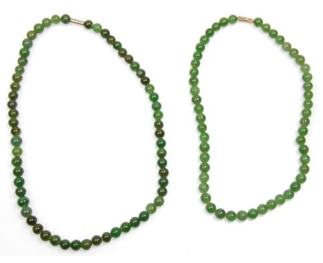 Two vintage mid century hard stone jade bead necklaces. Each having graduating beads with white metal barrel clasps to each. 