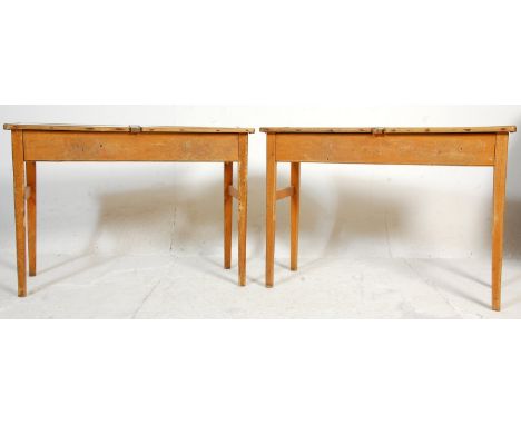 A pair of retro mid century, circa 1950's school desks. Each raised on squared legs with returns having hinged top desks abov