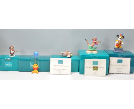 A group of five Walt Disney ceramic figurine ornaments to include Mickey Mouse Holiday 1998, Winnie The Pooh and His Ballon, 