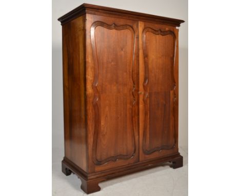 A Victorian 19th century mahogany bachelor's wardrobe armoire. Raised on bracket feet with twin fielded full length panel doo
