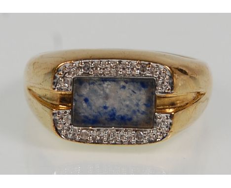 A thick 9ct yellow gold ring set with a blue stone panel and split diamond illusion surround. Stamped DIA and hallmarked 375 