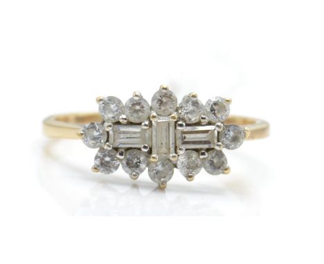 A hallmarked 9ct gold and white stone cluster ring. The ring set with baguette white stones surrounded by a halo of round cut