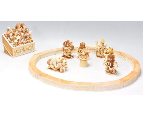 A group of Harmony Kingdom resin figurines in the form of a circus ring with spectators and performers, including a contortio