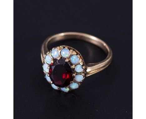 Opal-Granat-Ring 375er Gelbgold (9 ct). Ringgröße: 53-54. 3 Gramm. Gerillte Schiene mit Feingehaltspunze. 1 facettierter Gran