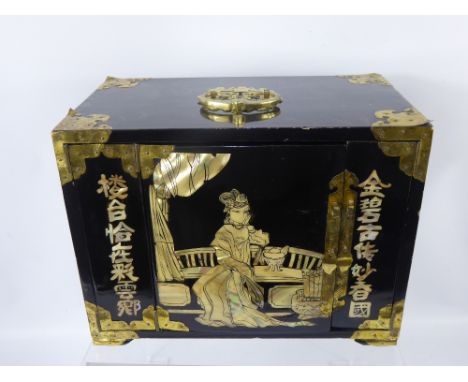 A Black Lacquer Oriental Jewellery Chest, with mother of pearl decoration, single folding door which, when opened reveal four