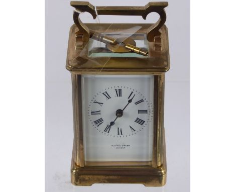 A 8 Day Brass Carriage Clock, white enamel face with Roman dial, stamped Mappin & Webb, London, with a French movement back p