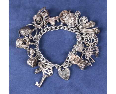 A silver charm bracelet with 18 charms. 92gms