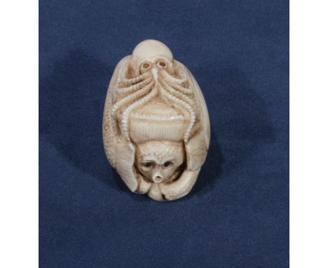 A signed ivory netsuke of an octopus with fish