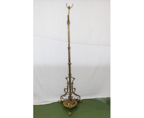 An Art Nouveau brass standard lamp supported by three paw feet