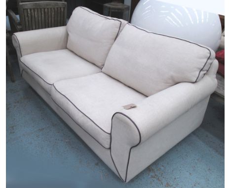 SOFA, two seater, in neutral fabric with piping on bun supports, 188cm L.