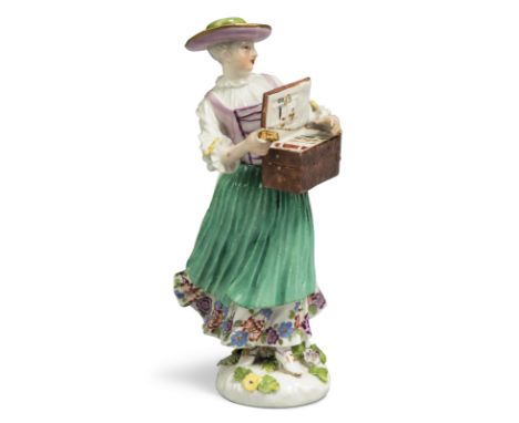 A Meissen porcelain figure of a trinket-seller, c.1745, wearing a green hat, puce bodice, white skirt with a flowered hem and