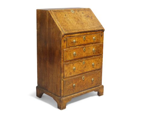 A George II walnut bureau, c.1740, of small proportions, the hinged fall front enclosing pigeon holes and drawers, above four