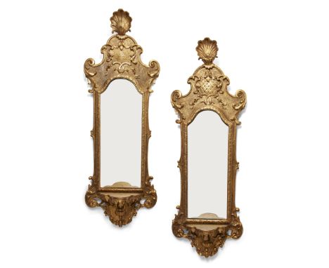 A pair of Italian giltwood pier mirrors, last quarter 19th century, the carved shell finial above shaped surmount with scroll
