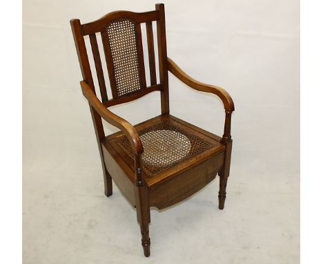 An Edwardian caned commode bedroom chair, with ceramic bowl and cover