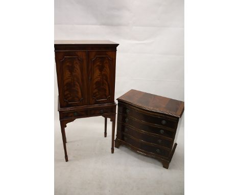 A reproduction mahogany drinks cabinet, having double doors to glass shelf interior over two short drawers on square tapering